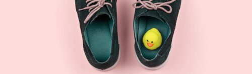 close-up of a pair of shoes with a rubber duck in the right shoe