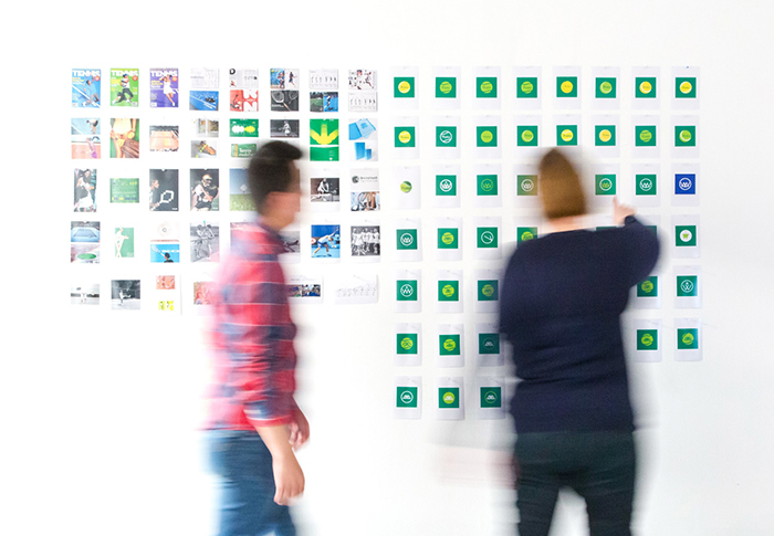 Two marketers standing in front of a wall collaborating with notes